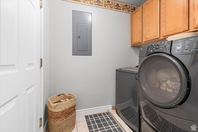 laundry room featuring light tile patterned floors, baseboards, separate washer and dryer, cabinet space, and electric panel