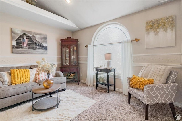living area with baseboards, vaulted ceiling, and carpet