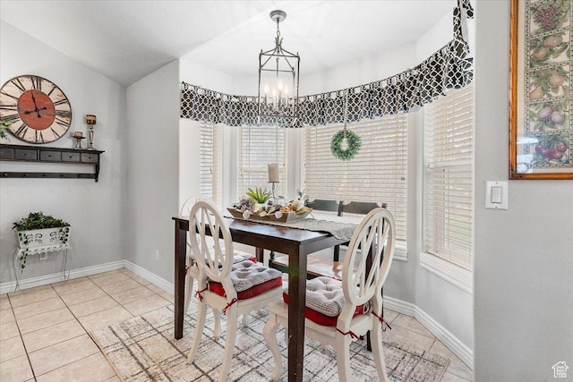 dining space with light tile patterned flooring, baseboards, and an inviting chandelier