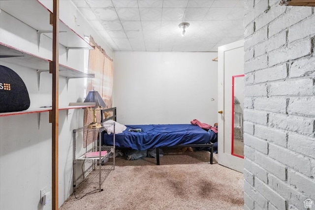 bedroom with carpet and brick wall