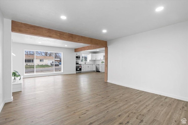4880 S 4380 W, Salt Lake City, UT 84118 - unfurnished living room with recessed lighting, beam ceiling, baseboards, and wood finished floors