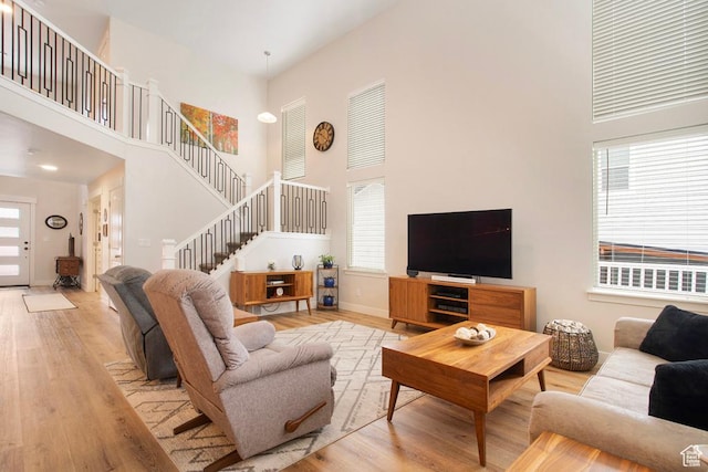 4143 W Gate Keeper Dr, Herriman, UT 84096 - living room featuring a high ceiling, wood finished floors, stairway, and baseboards