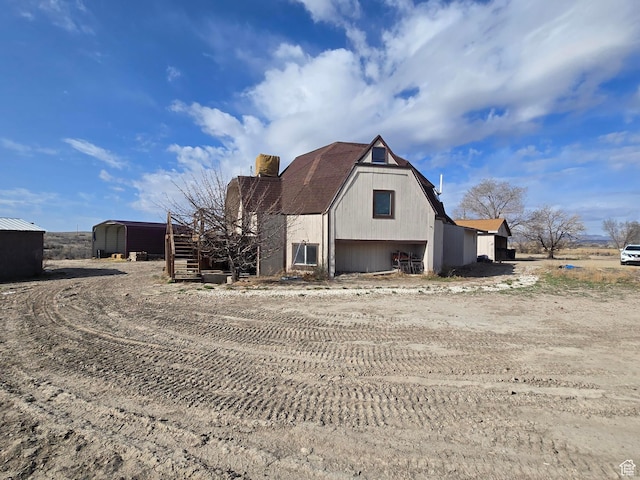 view of home's exterior featuring dirt driveway and a garage