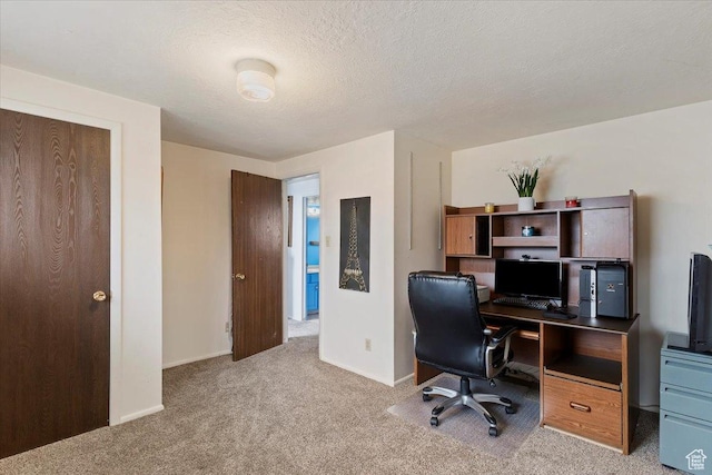 carpeted office space featuring baseboards and a textured ceiling