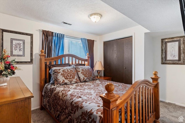 carpeted bedroom with baseboards, a textured ceiling, a closet, and visible vents