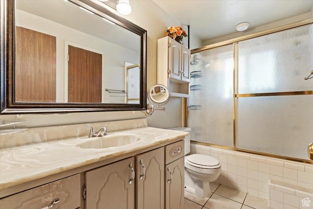 full bathroom featuring tile patterned flooring, vanity, combined bath / shower with glass door, and toilet