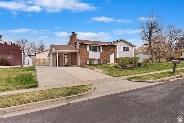 raised ranch featuring a storage unit, a front yard, and an outdoor structure