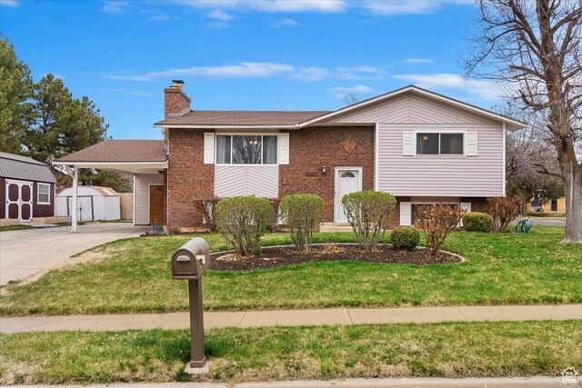 raised ranch featuring brick siding, a storage unit, driveway, an outdoor structure, and a carport
