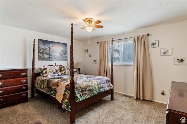 bedroom featuring light colored carpet, baseboards, a textured ceiling, visible vents, and a ceiling fan