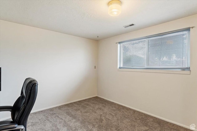 unfurnished office with carpet, baseboards, and visible vents