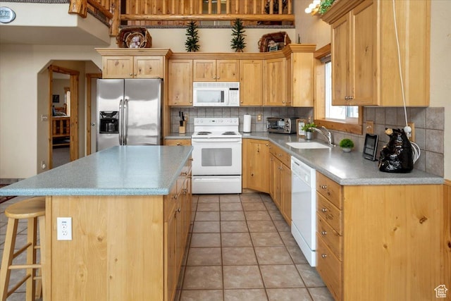 792 S Spruce Dr S, Garden City, UT 84028 - kitchen with white appliances, light tile patterned floors, a center island, decorative backsplash, and a sink