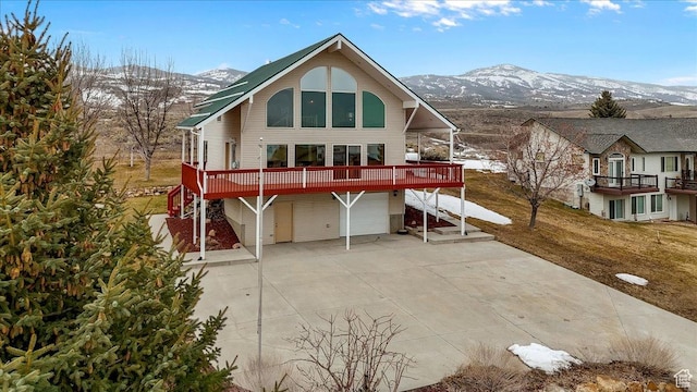 792 S Spruce Dr S, Garden City, UT 84028 - rear view of house with concrete driveway, a mountain view, and an attached garage