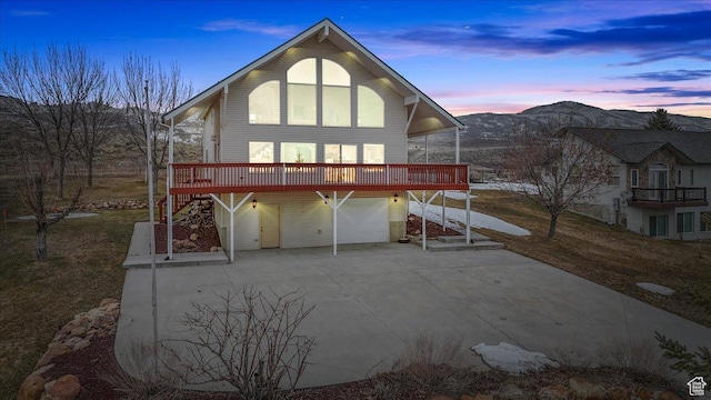 792 S Spruce Dr S, Garden City, UT 84028 - back of property at dusk with driveway, a deck, and an attached garage