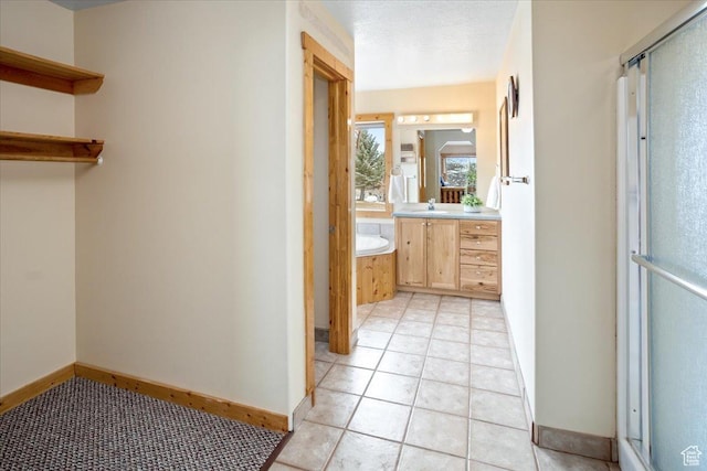 792 S Spruce Dr S, Garden City, UT 84028 - full bathroom with tile patterned flooring, vanity, baseboards, a stall shower, and a bath