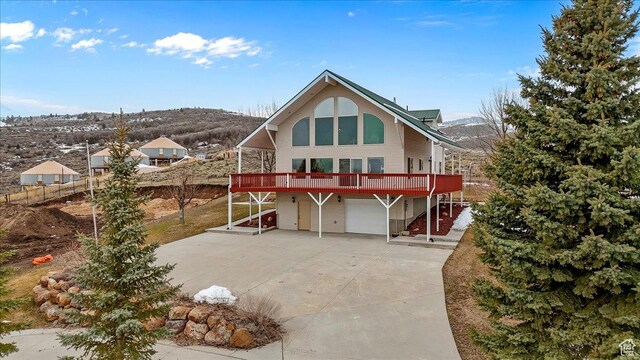 792 S Spruce Dr S, Garden City, UT 84028 - back of house featuring concrete driveway, a garage, and a deck with mountain view