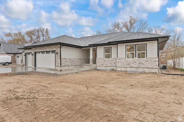 3779 S Old Wood, West Valley City, UT 84120 - view of front of home with an attached garage, stone siding, central AC, driveway, and fence