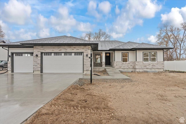 3779 S Old Wood, West Valley City, UT 84120 - view of front of house with an attached garage, concrete driveway, fence, and stone siding
