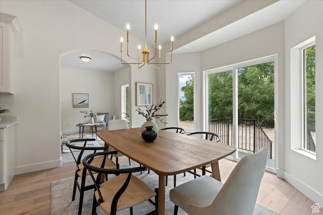 3779 S Old Wood, West Valley City, UT 84120 - dining area with arched walkways, baseboards, a chandelier, and light wood-style floors