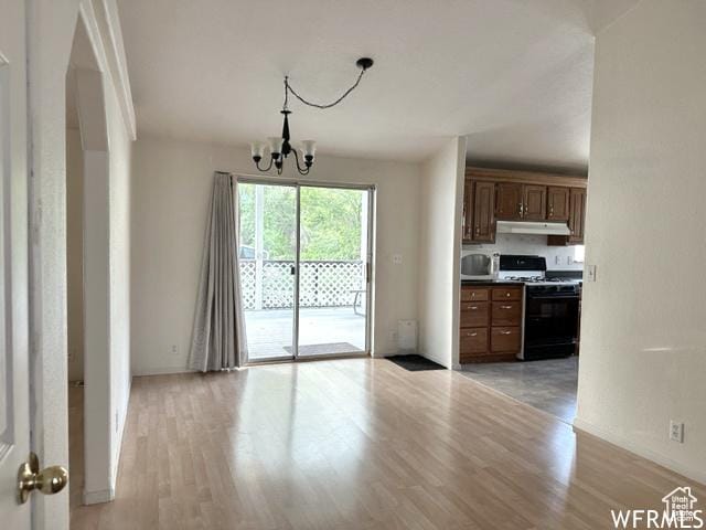 2103 S Mountain Vista Ln E, Provo, UT 84606 - kitchen featuring light wood-style flooring, gas range oven, under cabinet range hood, stainless steel microwave, and an inviting chandelier