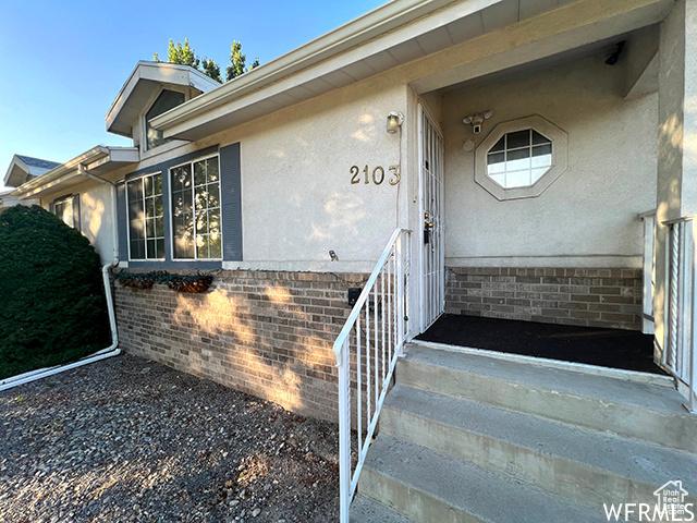 2103 S Mountain Vista Ln E, Provo, UT 84606 - view of exterior entry featuring stucco siding and brick siding