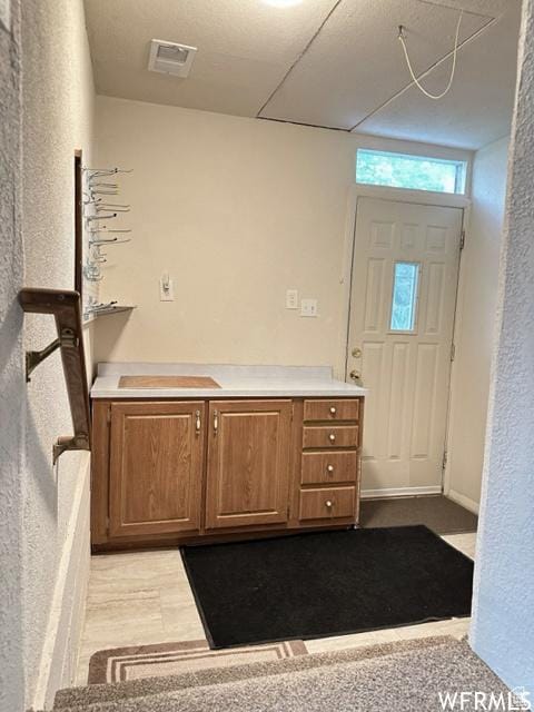 2103 S Mountain Vista Ln E, Provo, UT 84606 - interior space featuring light countertops, visible vents, brown cabinetry, and dark wood finished floors