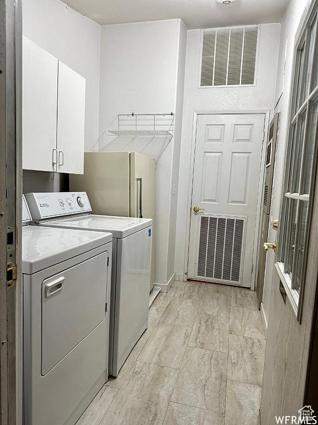 2103 S Mountain Vista Ln E, Provo, UT 84606 - laundry room with washer and clothes dryer, visible vents, and cabinet space