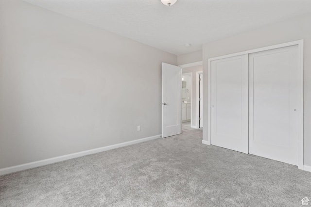 unfurnished bedroom with baseboards, a closet, and carpet