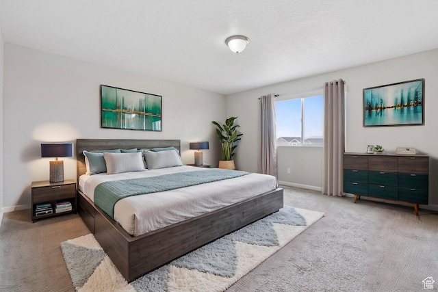 bedroom featuring light carpet and baseboards