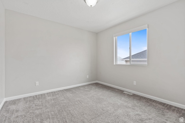 unfurnished room featuring baseboards, carpet flooring, and visible vents
