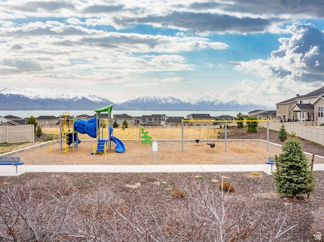 community jungle gym with a residential view, fence, and a mountain view
