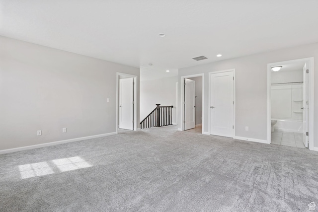 unfurnished bedroom with recessed lighting, baseboards, carpet floors, ensuite bath, and visible vents