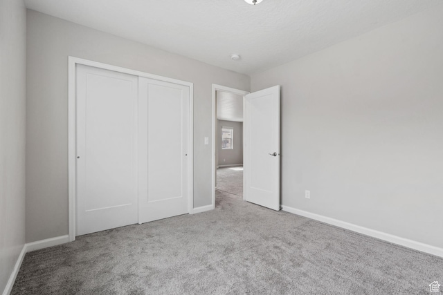 unfurnished bedroom featuring baseboards, a closet, and carpet