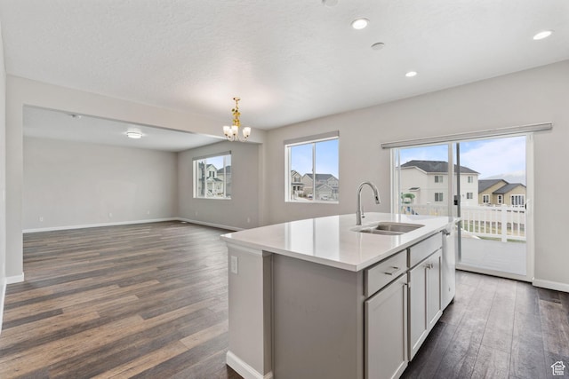 kitchen featuring an inviting chandelier, light countertops, a sink, and dark wood finished floors