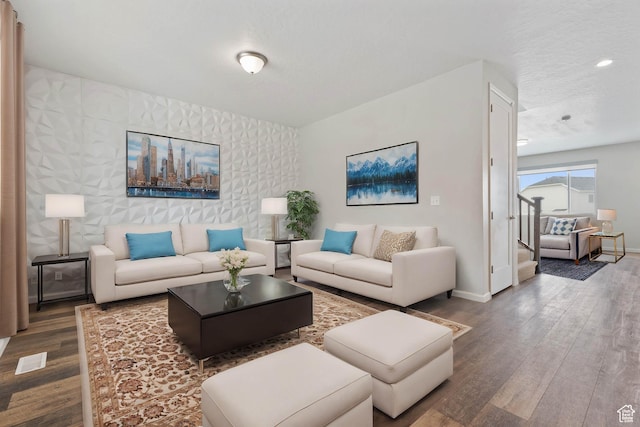 living room with baseboards, visible vents, and wood finished floors