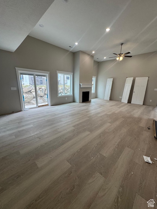 1870 N Valley View Dr Unit 201, Layton, UT 84040 - unfurnished living room featuring wood finished floors, ceiling fan, recessed lighting, a high ceiling, and a fireplace