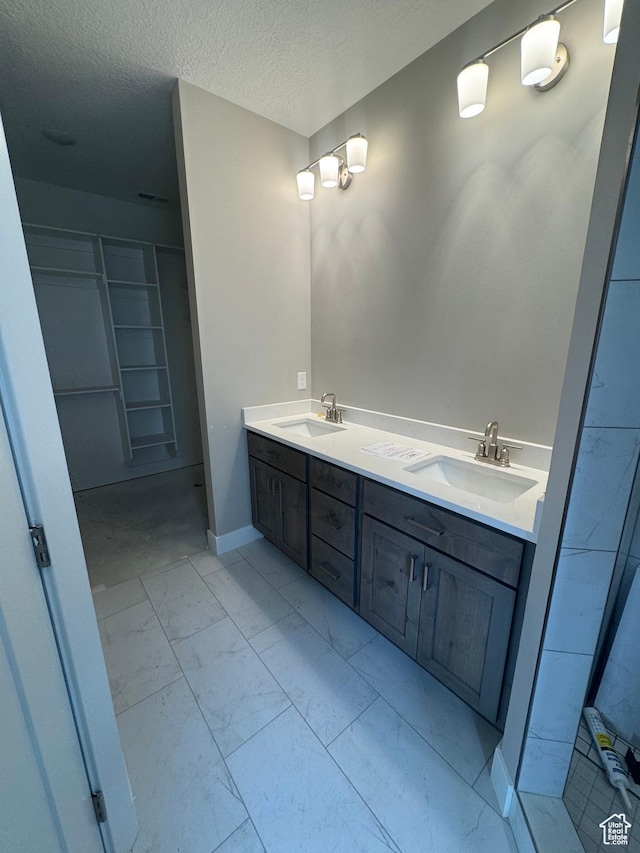 1870 N Valley View Dr Unit 201, Layton, UT 84040 - full bathroom featuring marble finish floors, a textured ceiling, double vanity, and a walk in closet