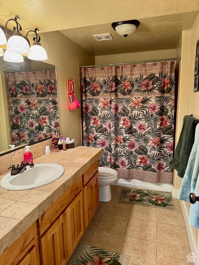 29 W Tamarind Way, Garden City, UT 84028 - bathroom with visible vents, vanity, toilet, a textured ceiling, and tile patterned floors