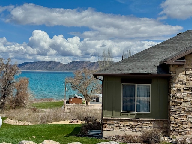 29 W Tamarind Way, Garden City, UT 84028 - view of home's exterior with board and batten siding, a shingled roof, stone siding, and a water and mountain view