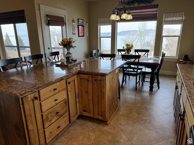 29 W Tamarind Way, Garden City, UT 84028 - kitchen featuring a healthy amount of sunlight, tile patterned flooring, an inviting chandelier, and hanging light fixtures