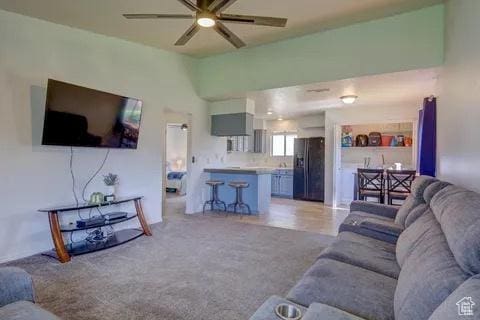 living room featuring a ceiling fan and light carpet