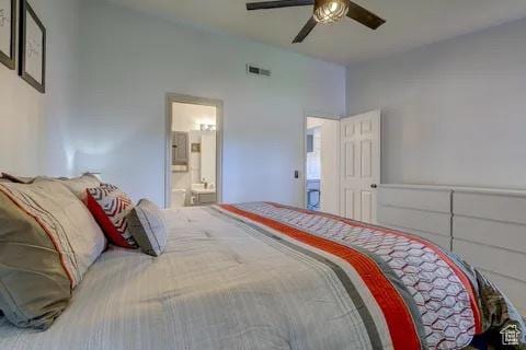 bedroom featuring connected bathroom, visible vents, vaulted ceiling, and a ceiling fan
