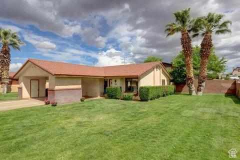 single story home with a front yard, driveway, and stucco siding