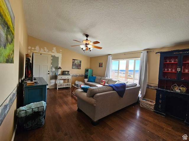 living area featuring dark wood finished floors, a textured ceiling, vaulted ceiling, and a ceiling fan