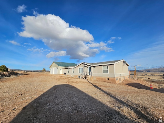 rear view of property featuring driveway, an attached garage, and crawl space