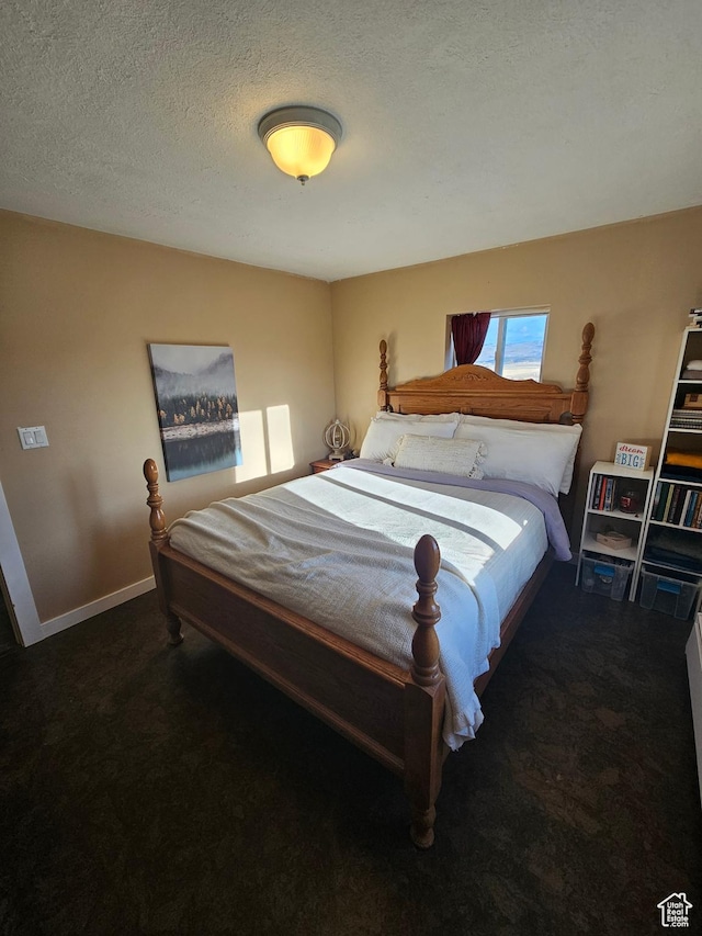 carpeted bedroom featuring baseboards and a textured ceiling
