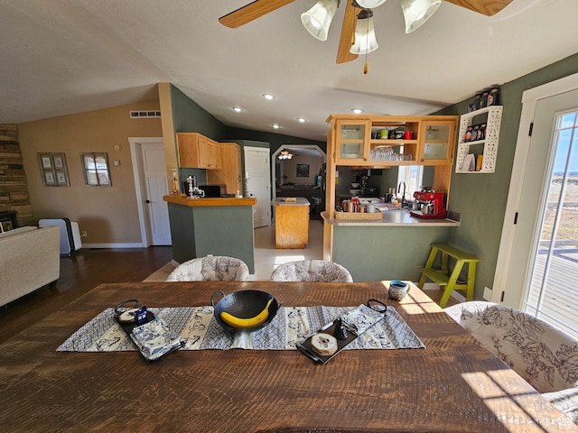 dining area featuring vaulted ceiling, a ceiling fan, wood finished floors, baseboards, and visible vents