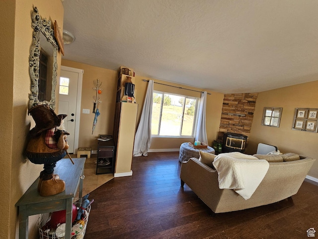 living room featuring baseboards, a textured ceiling, and hardwood / wood-style flooring