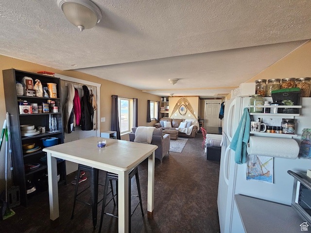 dining area featuring dark carpet and a textured ceiling