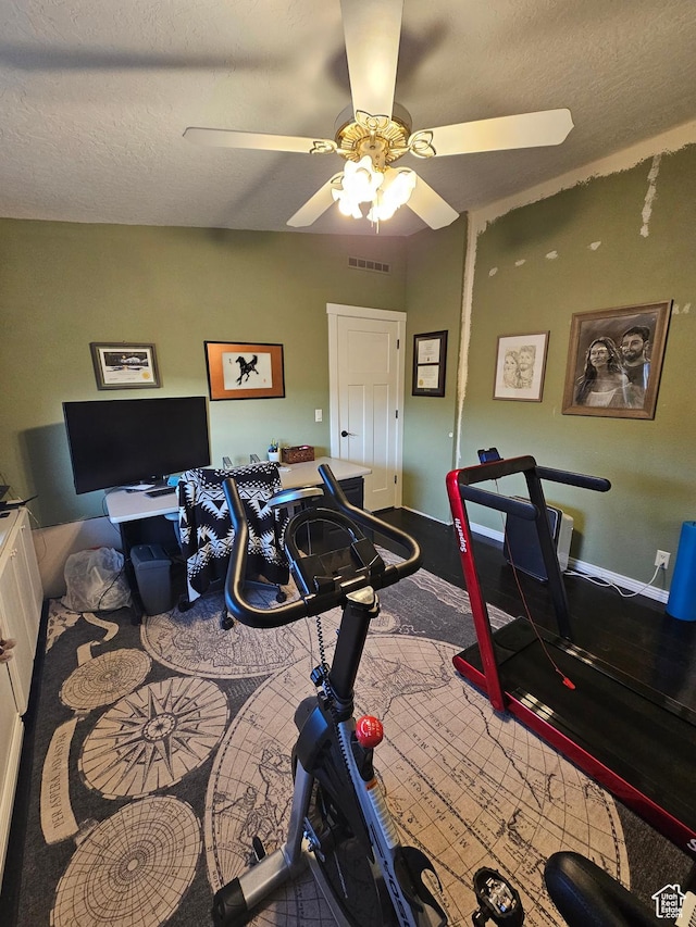 exercise room with a ceiling fan, a textured ceiling, and visible vents