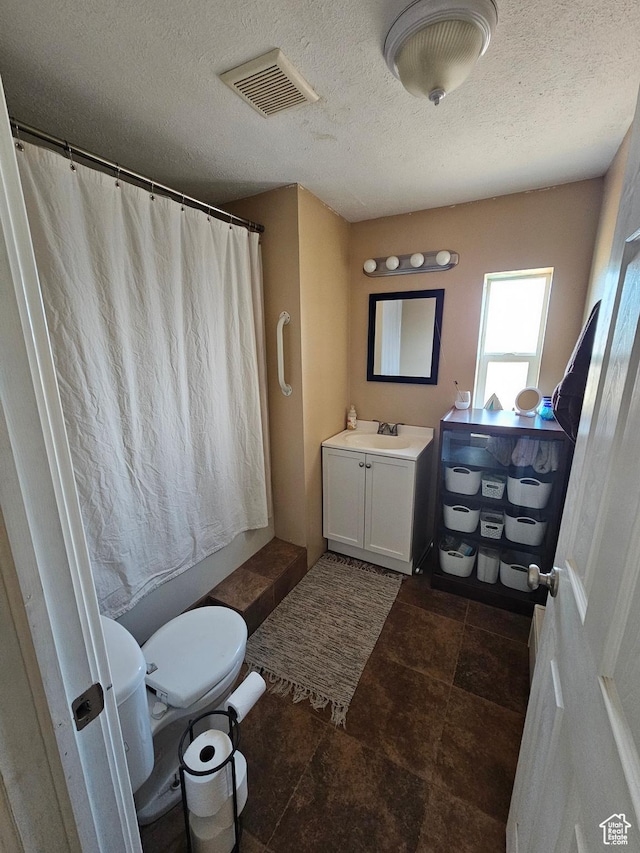 bathroom with a textured ceiling, visible vents, a shower with shower curtain, toilet, and vanity